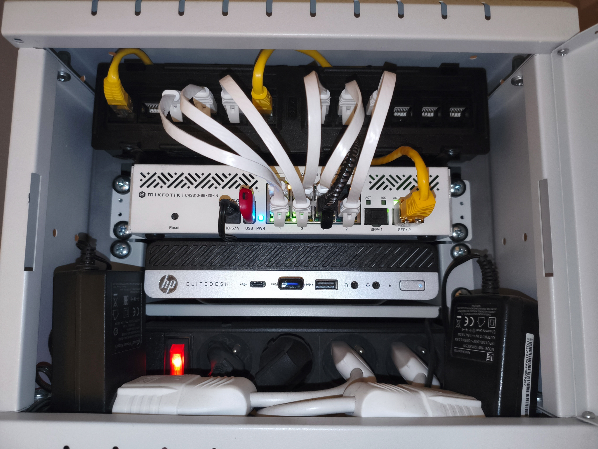 Fragment domowego homelabu SPD PC Build — szafa rack z urządzeniami sieciowymi i serwerem